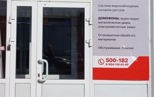 Вход в офис Иркутск Спец-Защита: стеклянная дверь и баннер компании «Домофоны, аудио-видео» с телефоном 500-182